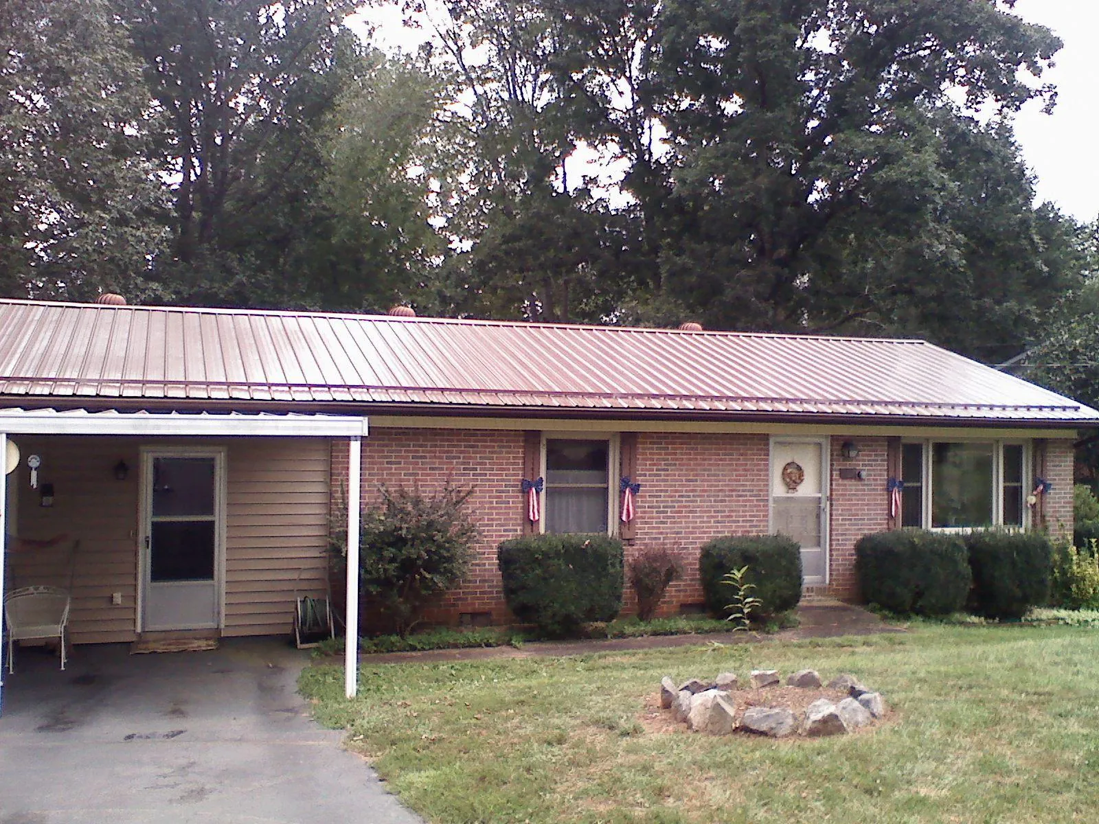 Bronze metal roof and carport on a brick ranch home — Roof Repair work by our crew in Neah Bay